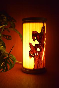 Kleine, handgefertigte Olimba Tischlampe aus Olivenholz und Limba, die warmes und stimmungsvolles Licht spendet. Ideal für Schreibtische oder Nachttische.