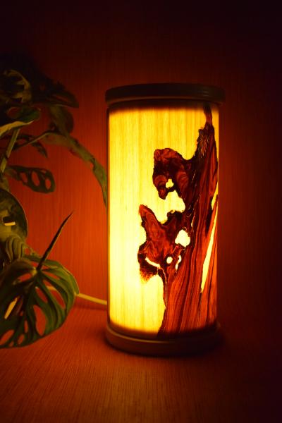 Kleine, handgefertigte Olimba Tischlampe aus Olivenholz und Limba, die warmes und stimmungsvolles Licht spendet. Ideal für Schreibtische oder Nachttische.