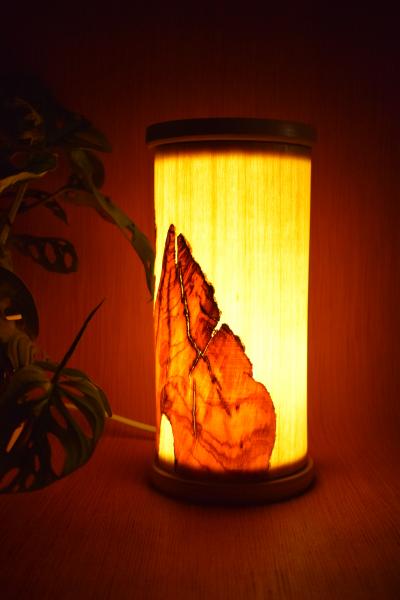 Kleine, handgefertigte Olimba Tischlampe aus Olivenholz und Limba, die warmes und stimmungsvolles Licht spendet. Ideal für Schreibtische oder Nachttische.