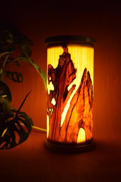 Kleine, handgefertigte Olimba Tischlampe aus Olivenholz und Limba, die warmes und stimmungsvolles Licht spendet. Ideal für Schreibtische oder Nachttische.